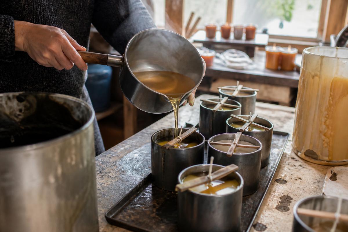 Warm wax being poured into molds on a workbench